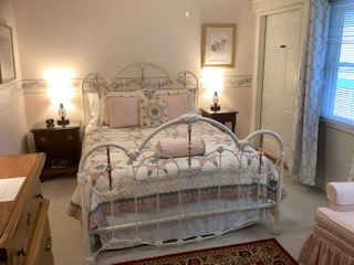 Patricia's room has a romantic theme. The sitting area has 2 armchairs.  Soak in the claw foot, hand painted tub or use the shower in the private bathroom. The room overlooks the side lawn.